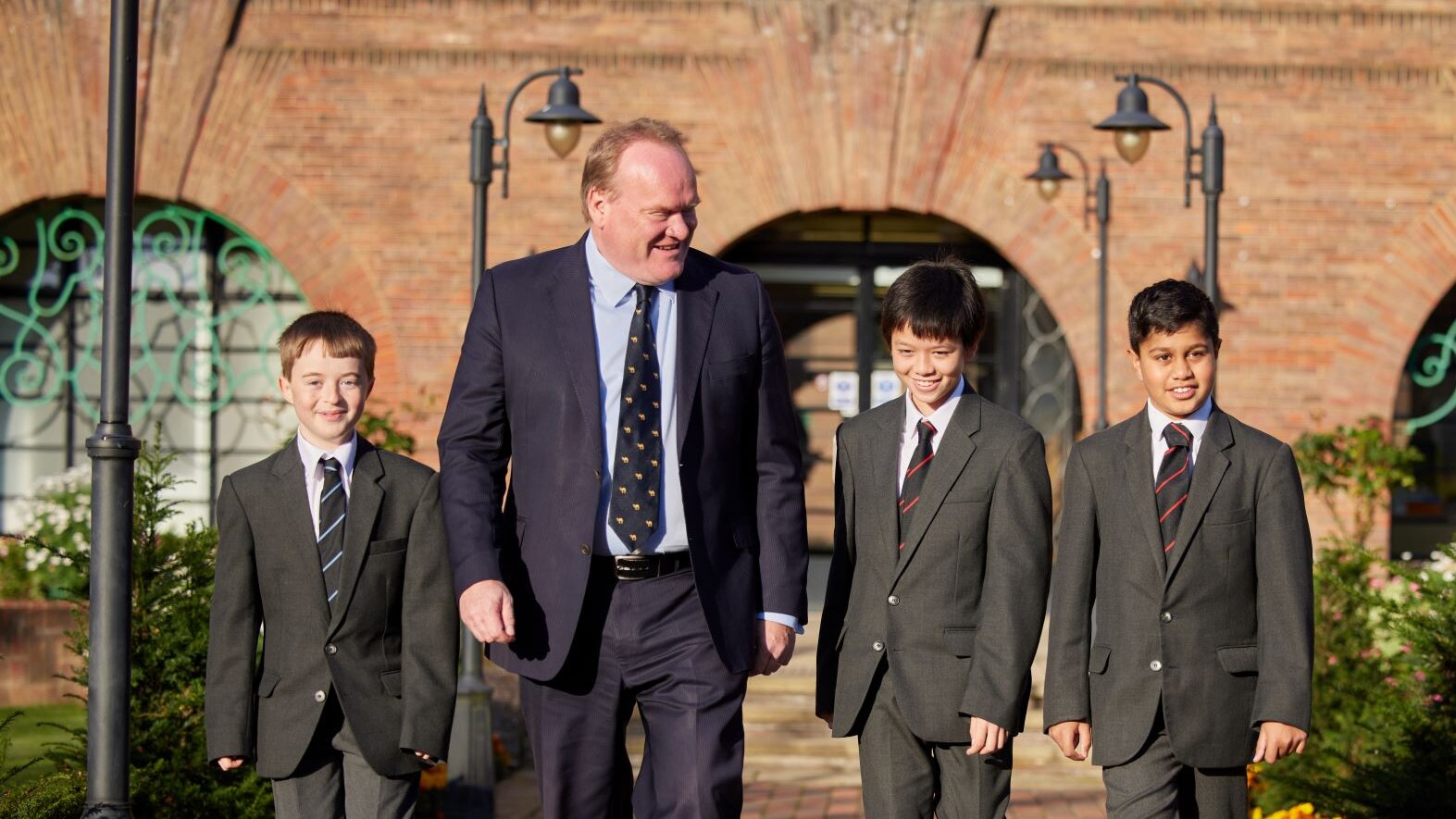Simon Everson, Head Teacher at Merchant Taylors' School walking with three school pupils