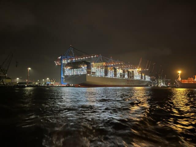 Cargo ship docked in hamburg at night with lights around
