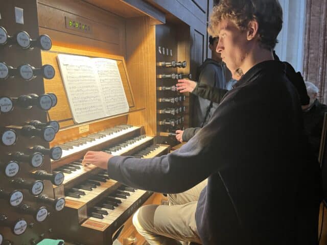 pupil plays the organ, photo looks on to the keys and stops being used
